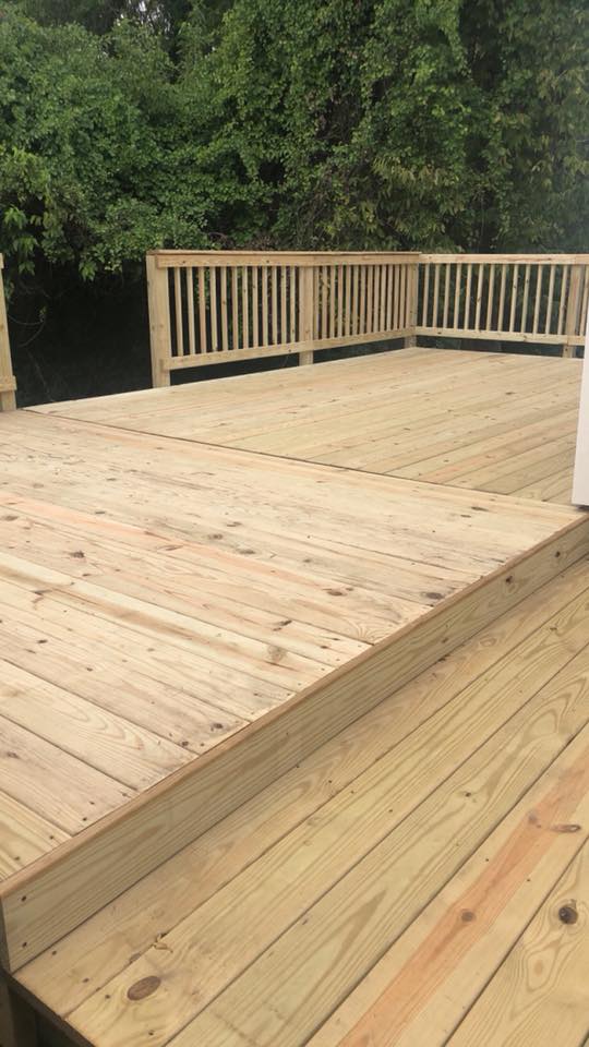 Multi-level wood deck connecting the home to a landscaped backyard retreat