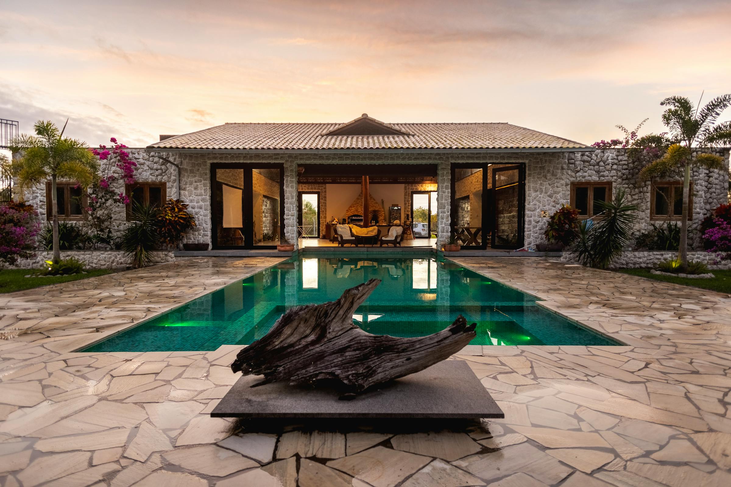 Golden-hour view of a custom resort-style pool and patio at a Central Indiana home