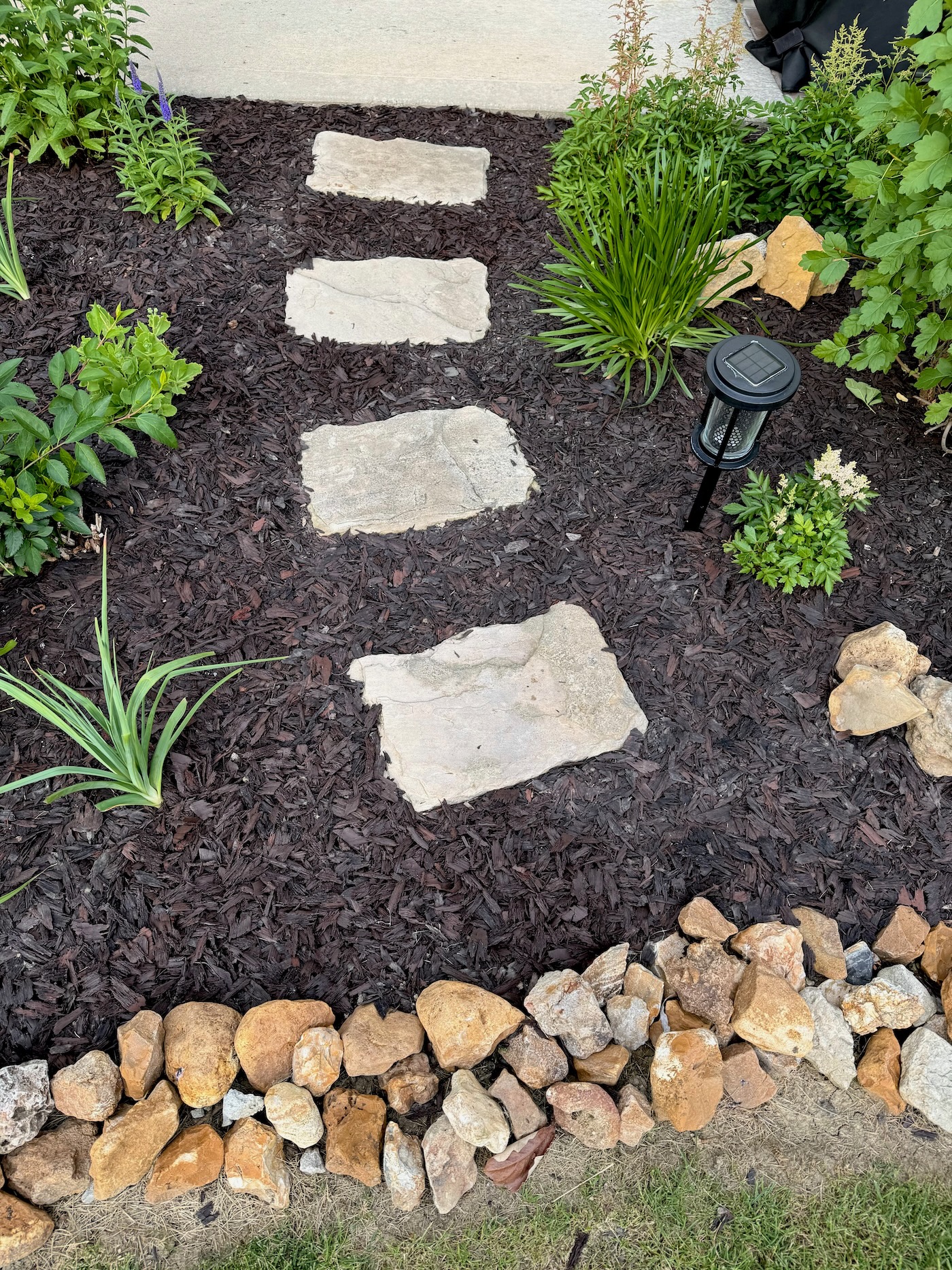 Paver walkway installed across a landscaped yard